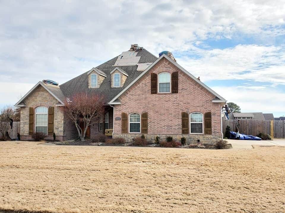 A large brick house with a lot of windows and shutters