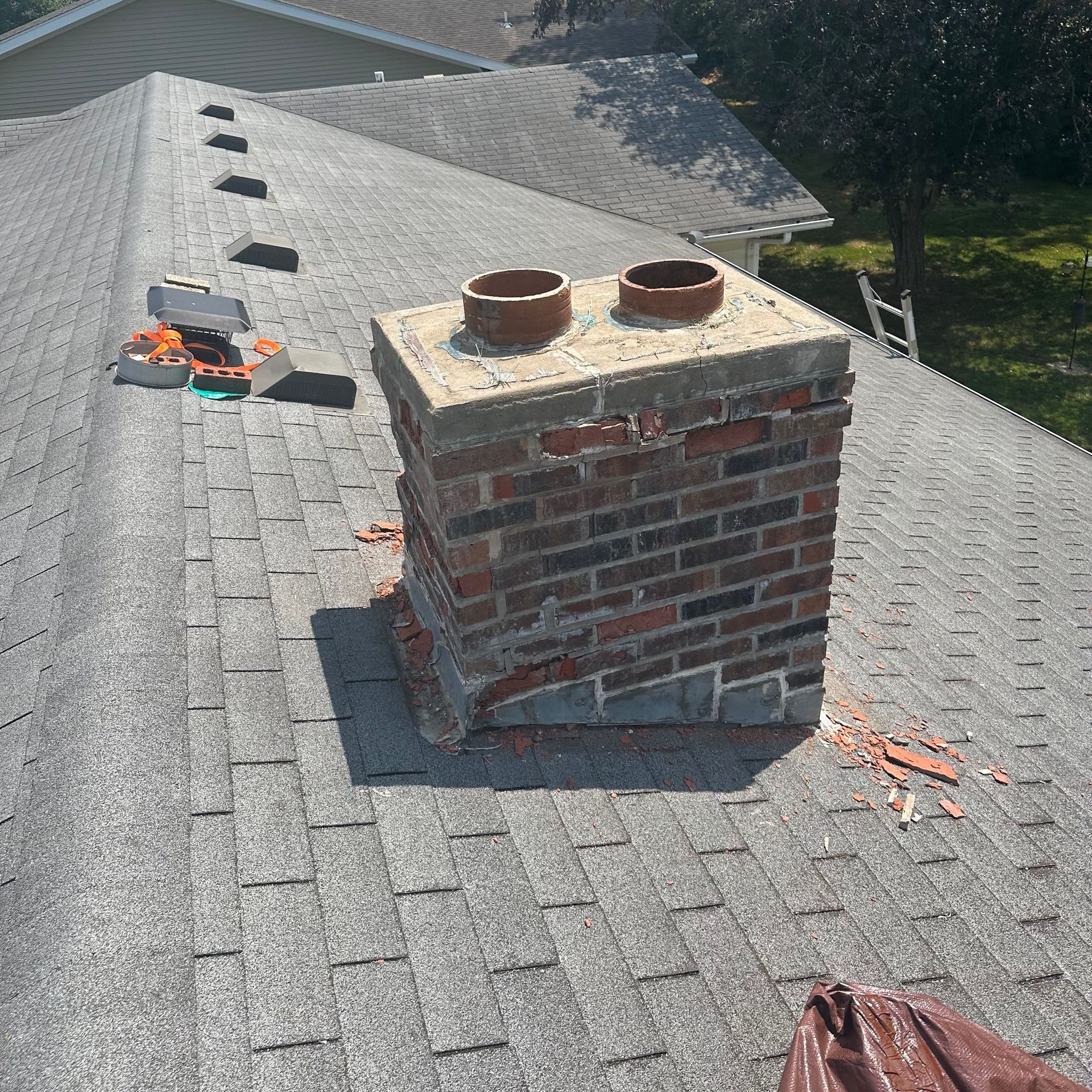 A brick chimney is sitting on top of a roof