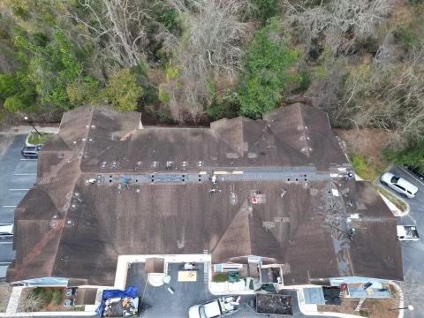 An aerial view of a roof of a building with trees in the background.