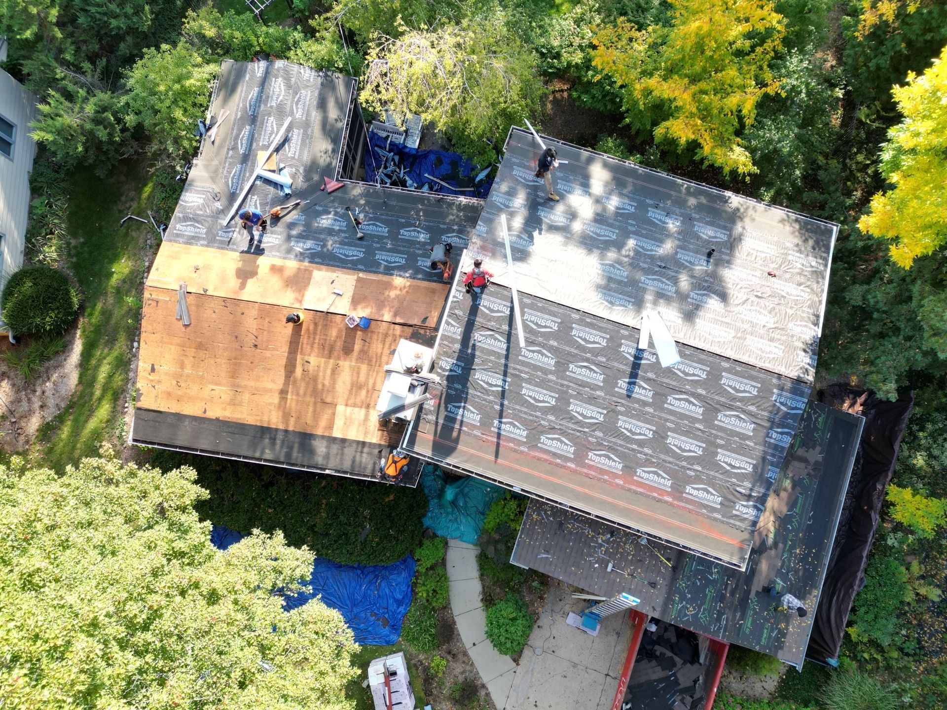 An aerial view of a house with a roof being installed.