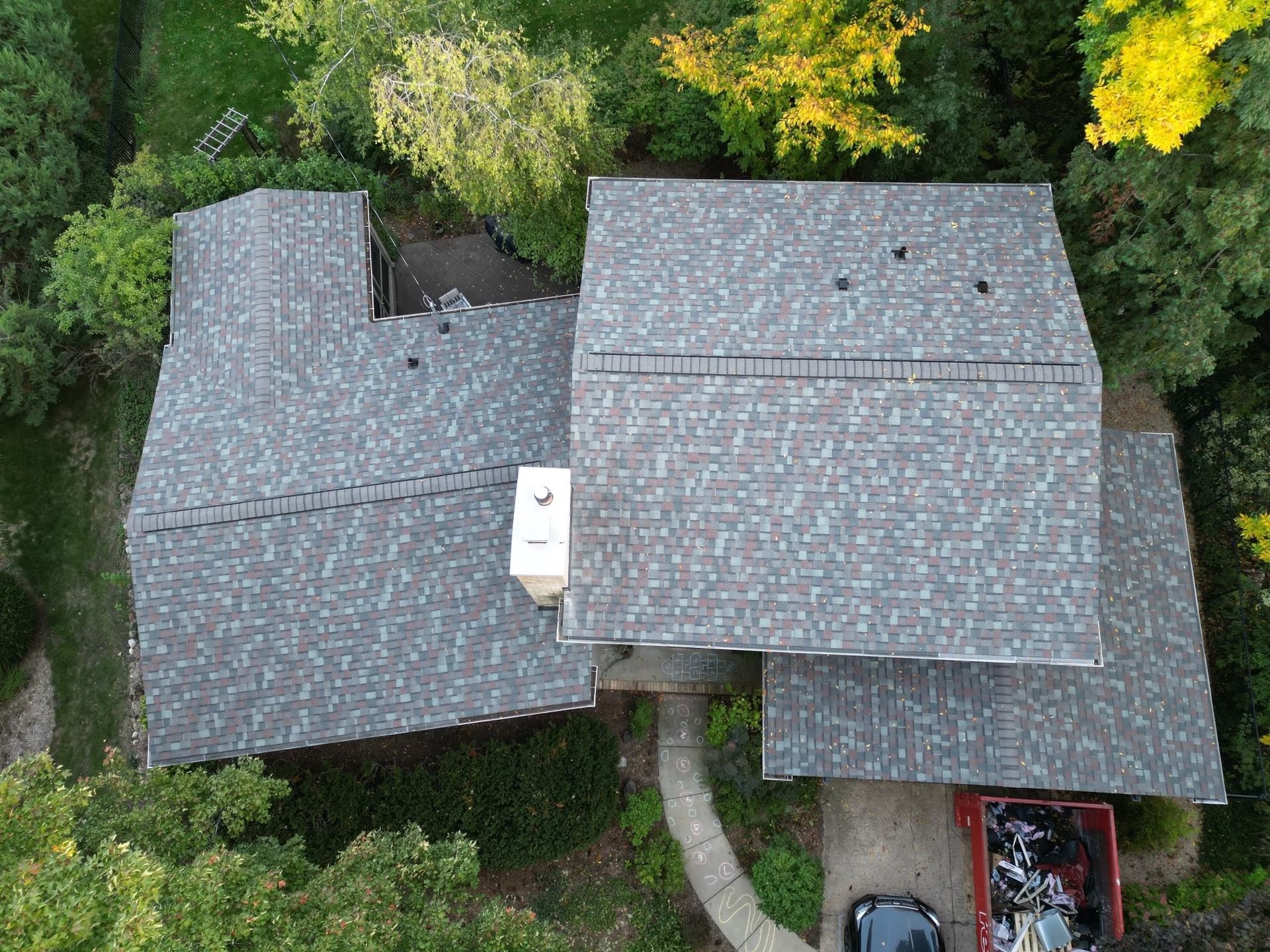 An aerial view of a house with a car parked in the driveway.