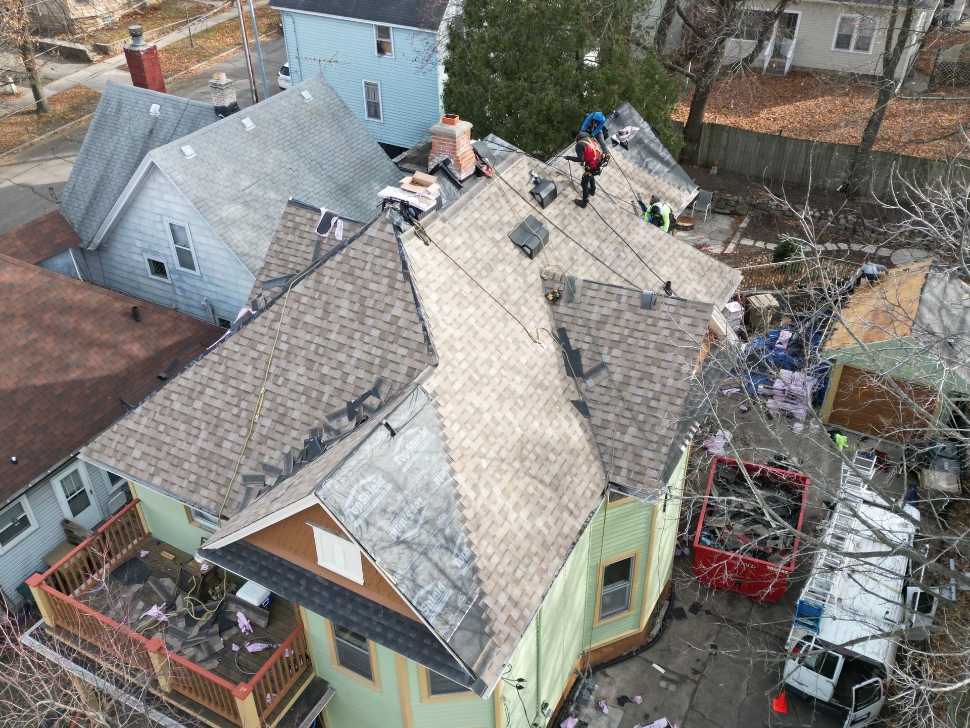 An aerial view of a house undergoing a roof replacement.