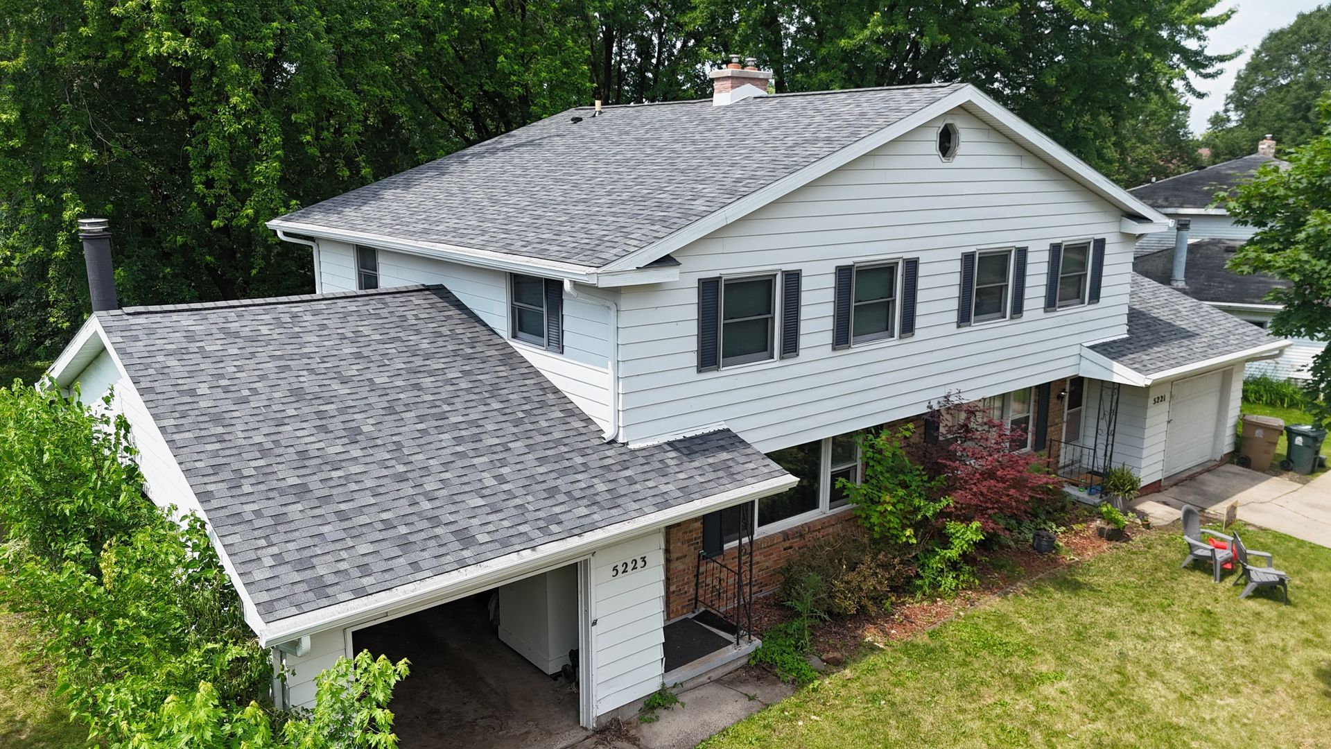 An aerial view of a large white house with a gray roof.