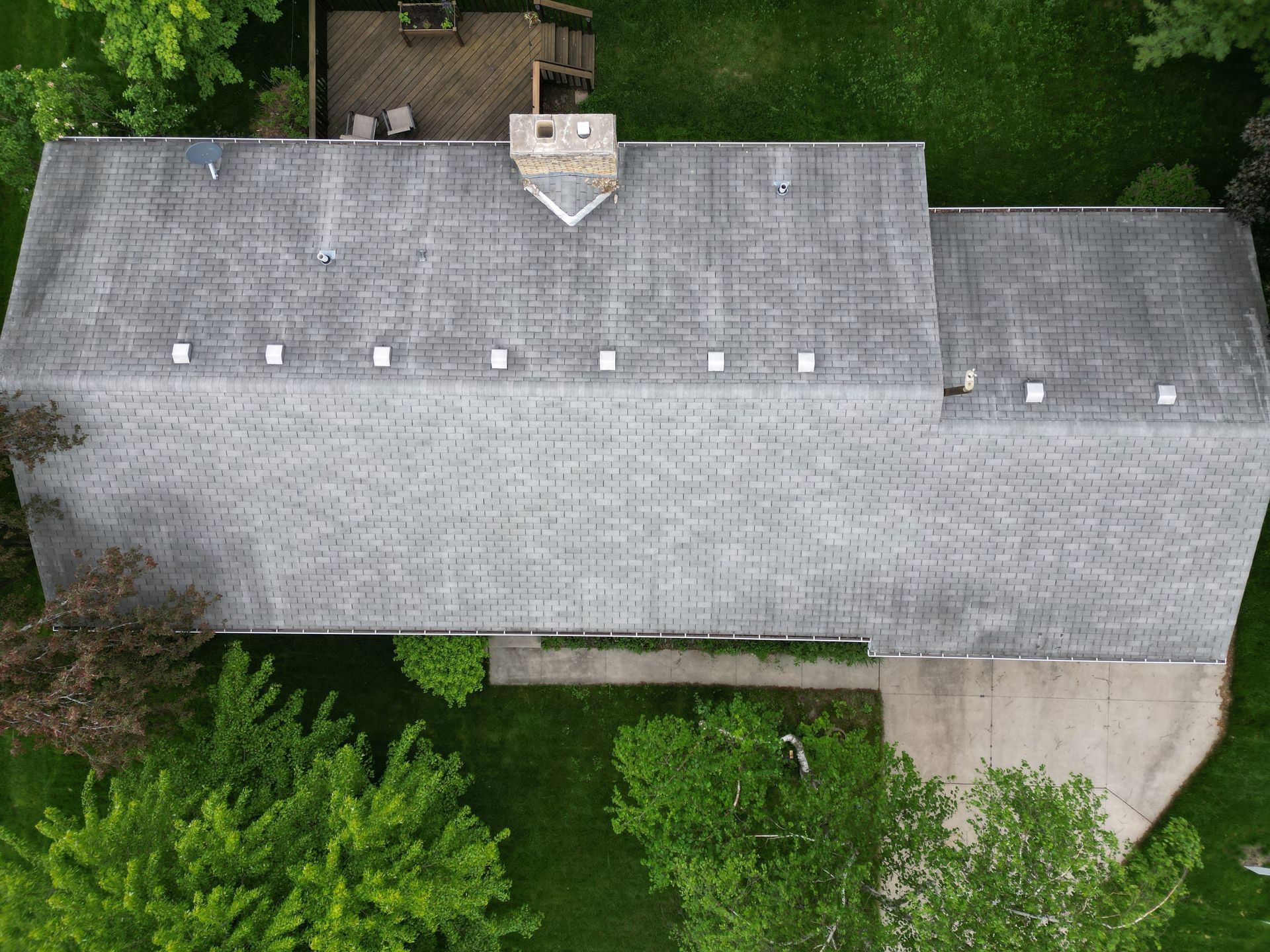 An aerial view of a house with a gray roof