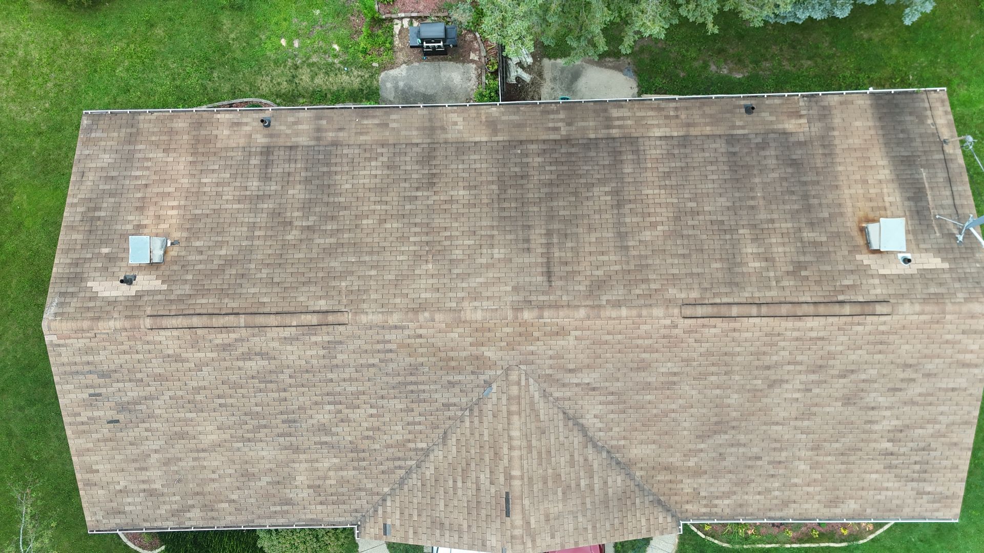 An aerial view of a house with a roof that is covered in moss.