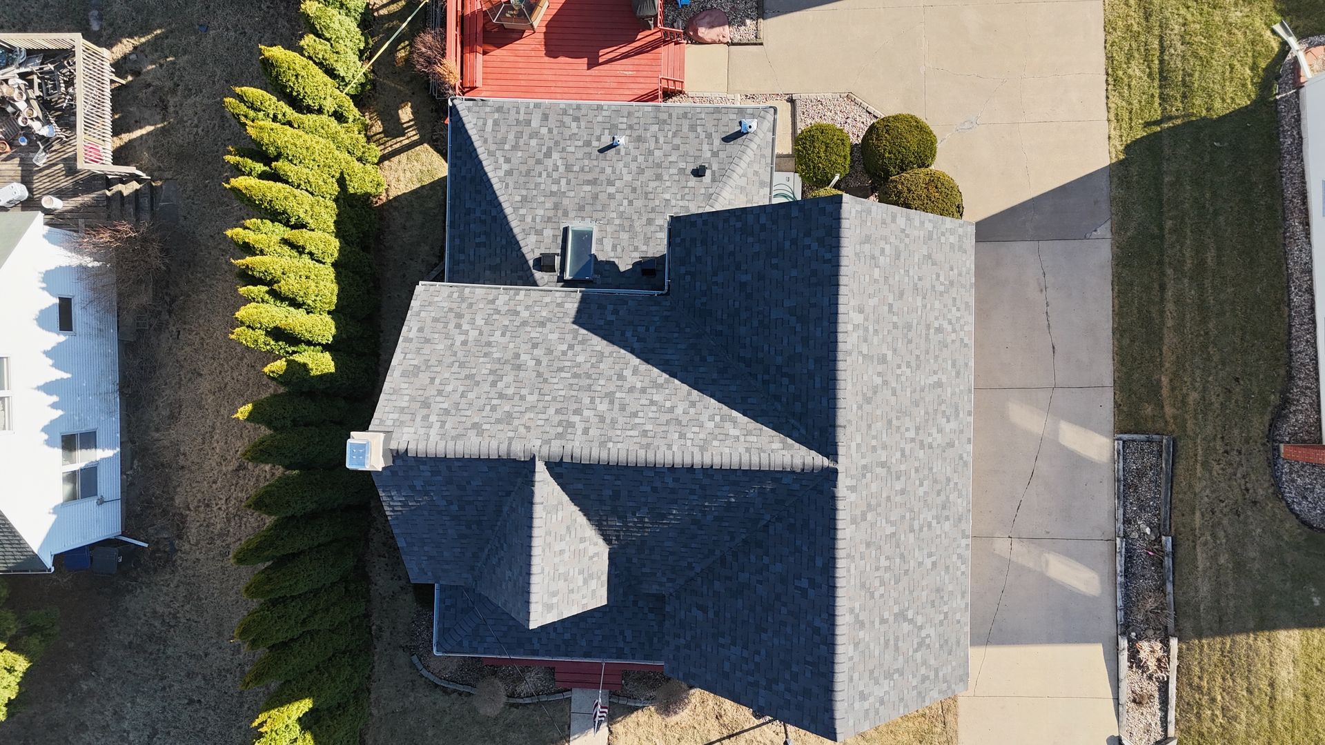 An aerial view of a house with a roof and a driveway.