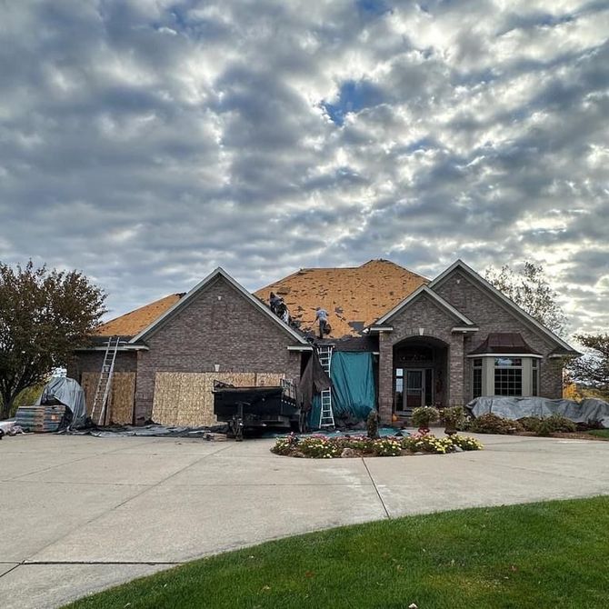 A house is being remodeled with a truck parked in front of it.