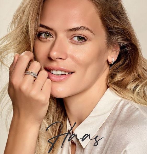 Een vrouw met een wit shirt en een ring aan haar vinger