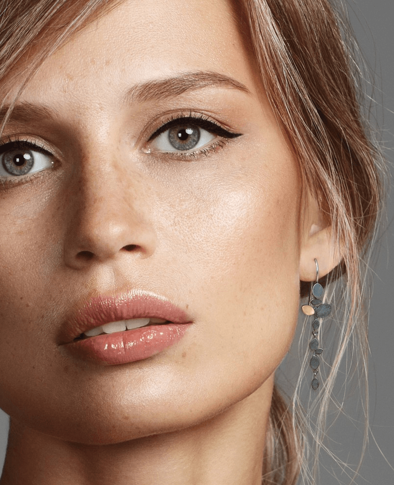 Een close-up van het gezicht van een vrouw met oorbellen.
