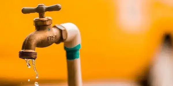 A close up of a water faucet with water dripping from it.
