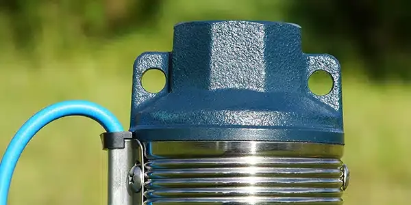 A close up of a water pump with a blue hose attached to it.