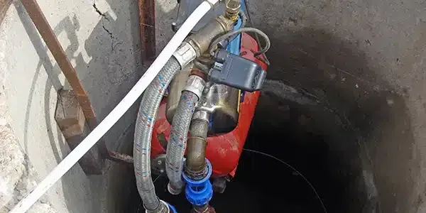 A close up of a water pump in a well.