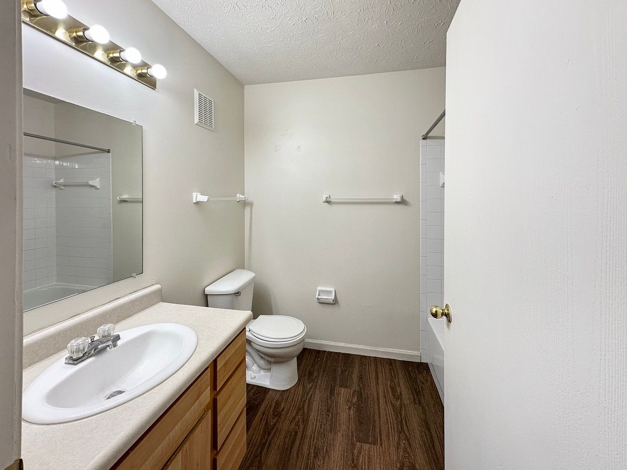 A bathroom with a toilet , sink and mirror