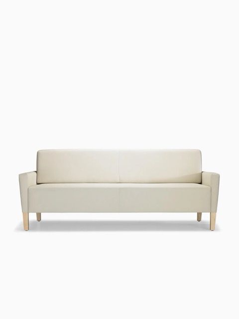 Beige upholstered sofa with wooden legs on a white background
