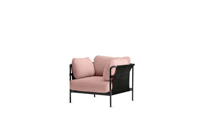 Pink armchair with black metal frame and plush cushions on a white background