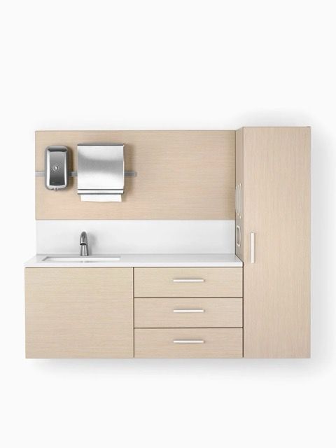 Light wood bathroom vanity with sink, mirror, paper towel dispenser, and tall cabinet on the right