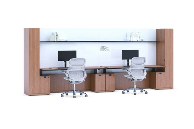 Modern office workstation with two desks, chairs, monitors, and wood paneling