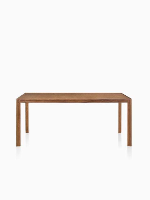 Rectangular wooden dining table with four legs on a white background