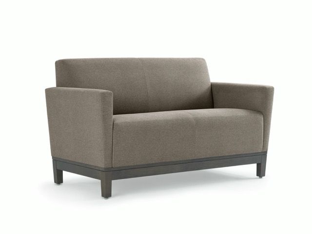 Modern beige upholstered loveseat with dark wooden legs on a white background