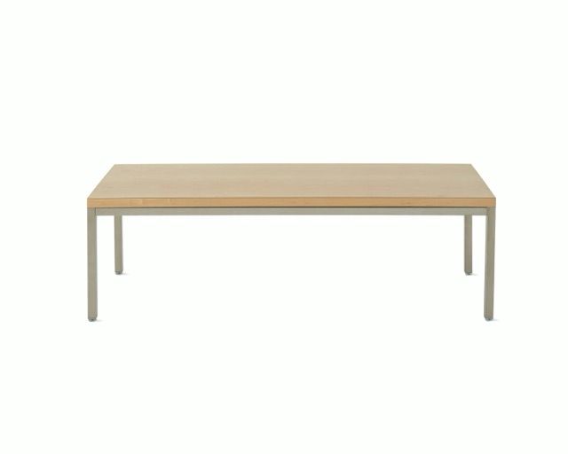Light wood rectangular table with four slender legs on a white background