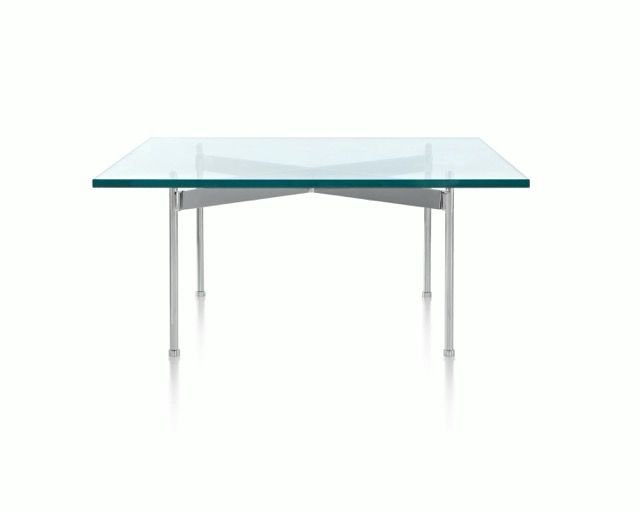 Glass-top modern table with silver metal legs on a white background.