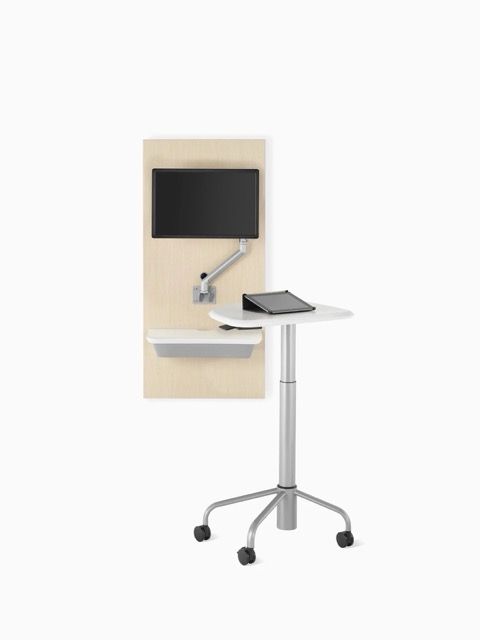 Wall-mounted monitor with adjustable arm beside a mobile standing lectern on wheels