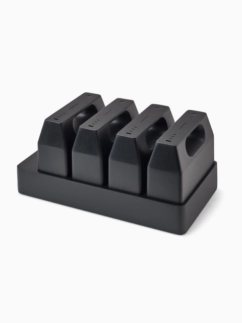 Black four-slot charging dock on a rectangular base with USB ports on each unit