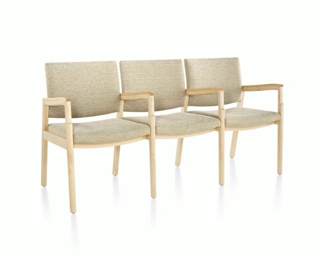 Three beige upholstered chairs with light wood frames arranged in a row on a white background