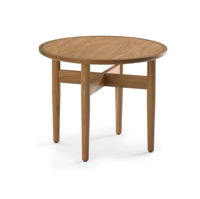 Round wooden table with four tapered legs on a white background