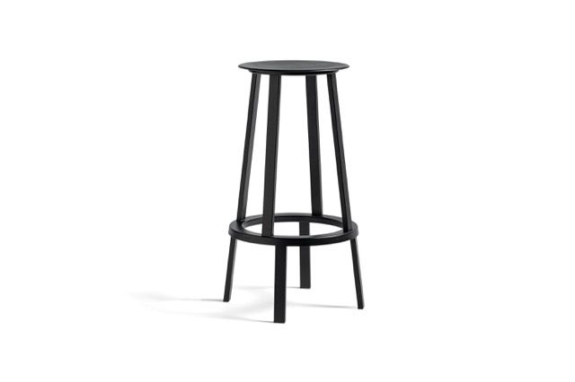 Black metal bar stool with round seat and footrest on a white background