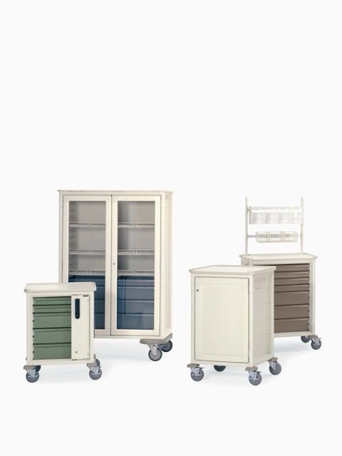 Two wheeled medical storage carts, one with glass doors and one with drawers, in white and blue-gray.