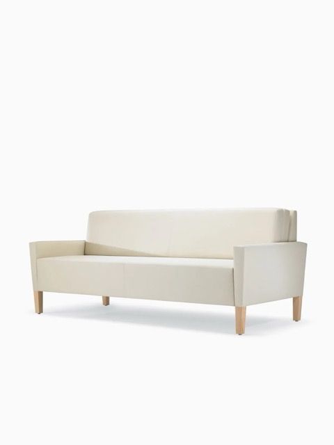 Beige upholstered sofa with wooden legs on a white background