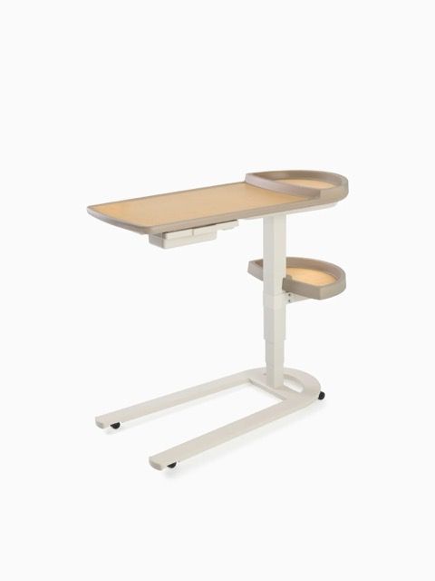 Adjustable white overbed table with light wood top and side trays on caster base