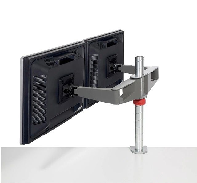 Dual black monitor mounts on a silver adjustable clamp arm attached to a desk pole.