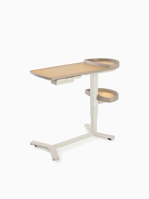 Adjustable white overbed table with light wood top and side trays on caster base