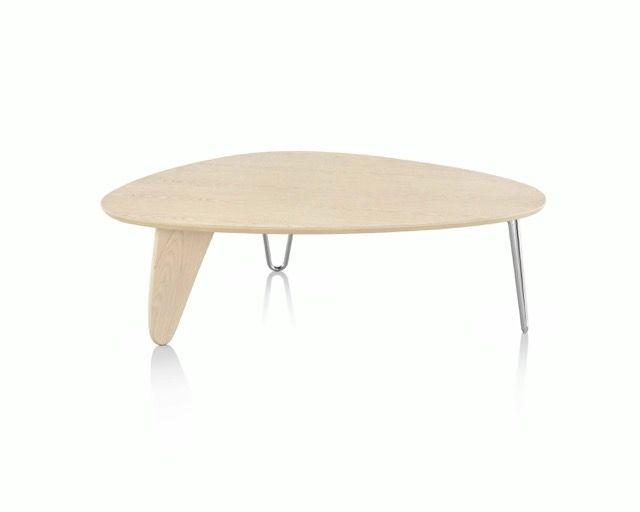 Light wood oval coffee table with three slender metal legs on a white background