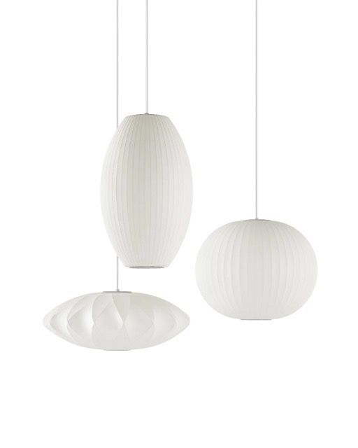 Three white pendant lamps with textured shades hanging against a plain white background