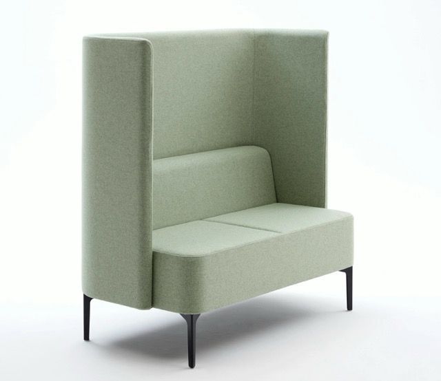Modern pale green upholstered armchair with high back and slim black legs on a white background