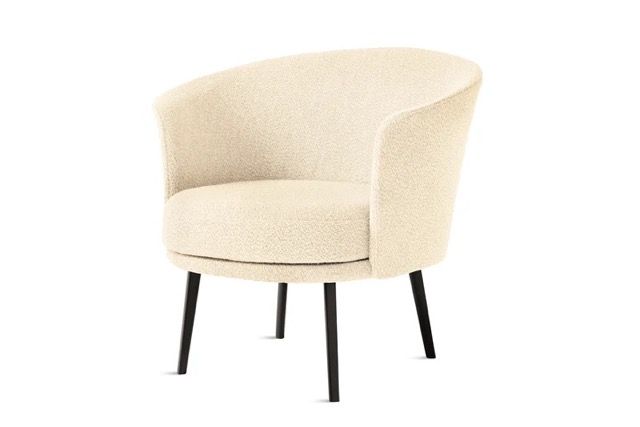 Cream upholstered armchair with black legs on a white background