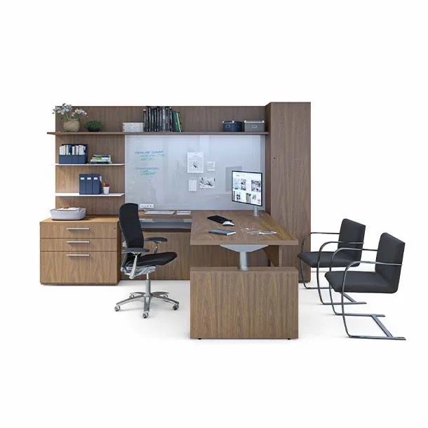 Modern office setup with wooden desks, black chairs, shelves, and a whiteboard