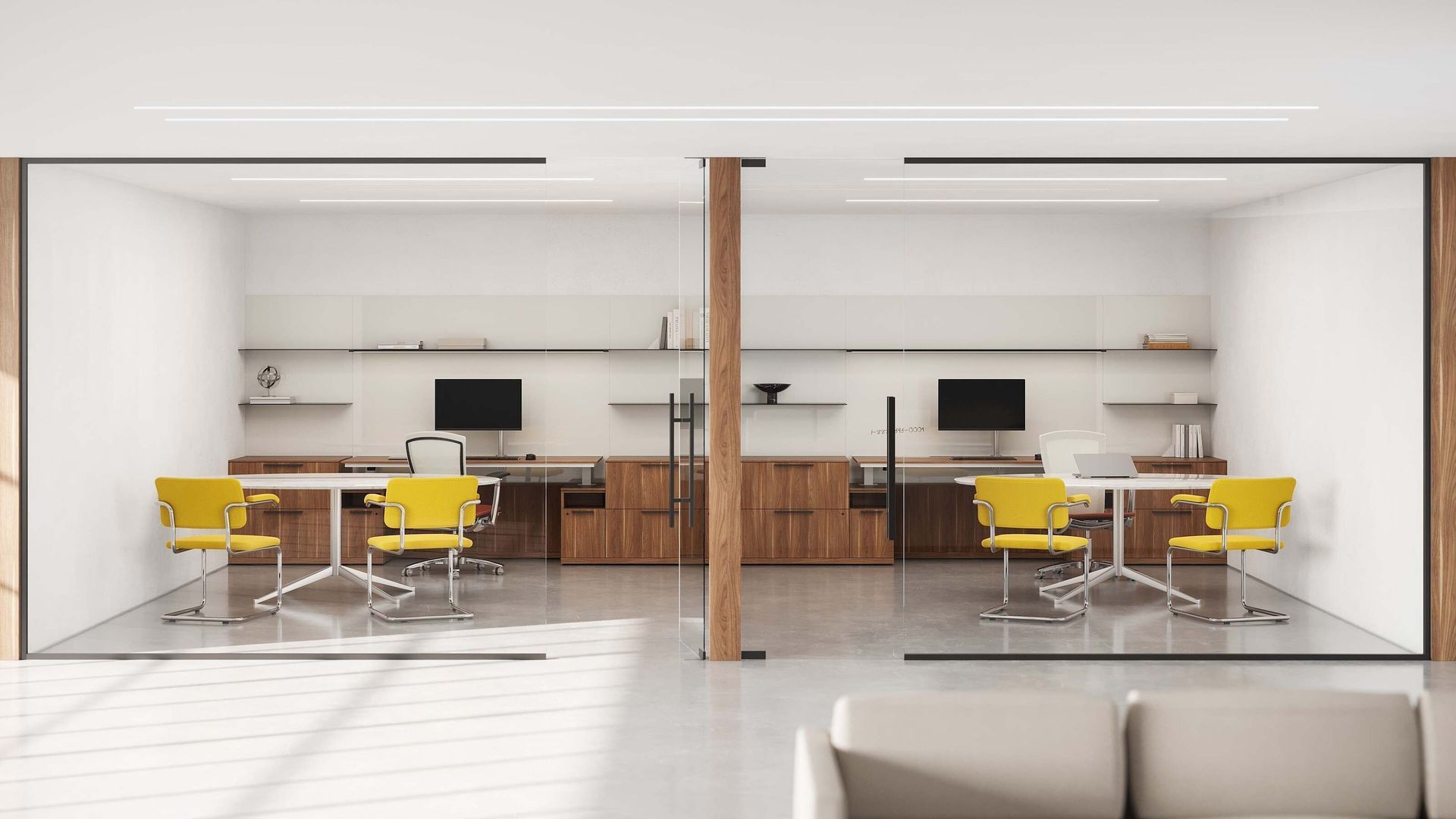 Modern open office with yellow chairs, desks, computers, and central wooden column, split into two mirrored workspaces