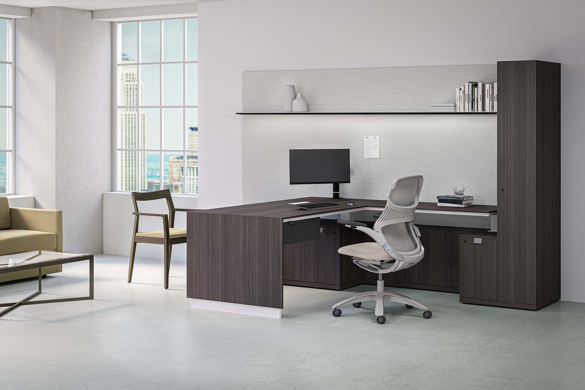 Modern office workstation with dark wood desk, white chair, computer monitor, shelves, and large window.