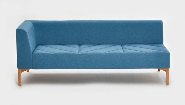 Blue modern three-seat sofa with wooden legs on a white background