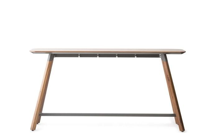 Minimalist wooden desk with angled legs and a gray support bar on a white background