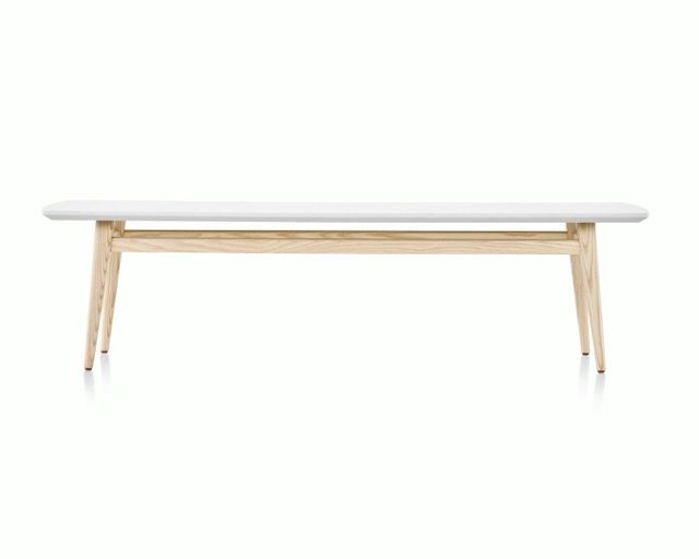 Minimalist white bench with light wood legs on a plain white background