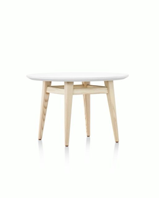 Round white table with light wood legs on a white background
