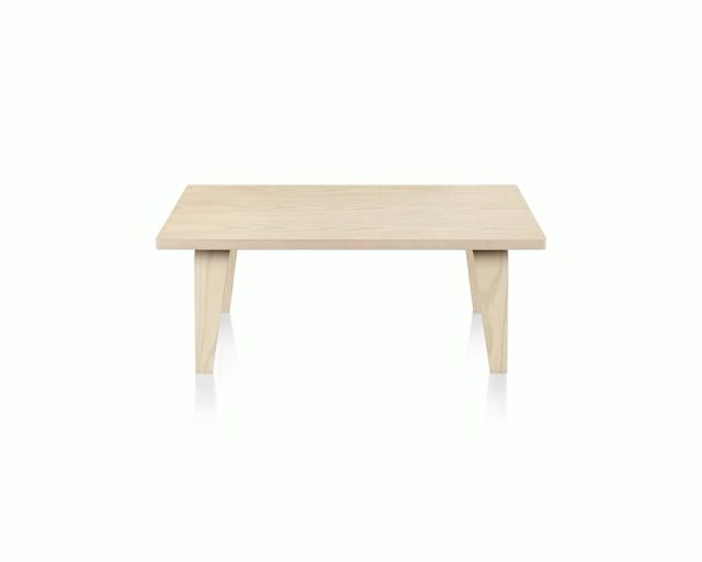 Light wood rectangular table with four tapered legs on a white background