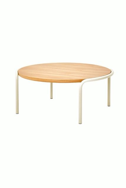 Round light wood table with white legs on a white background