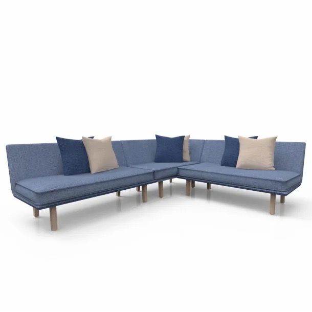 Blue L-shaped sectional sofa with beige and navy pillows on a white background