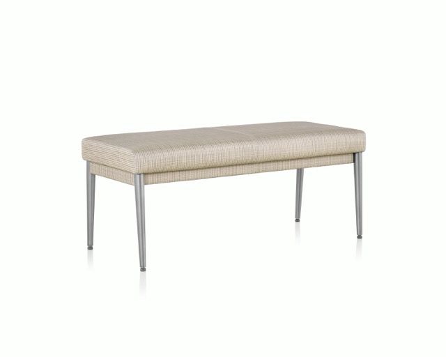 Beige upholstered bench with slim metal legs on a white background